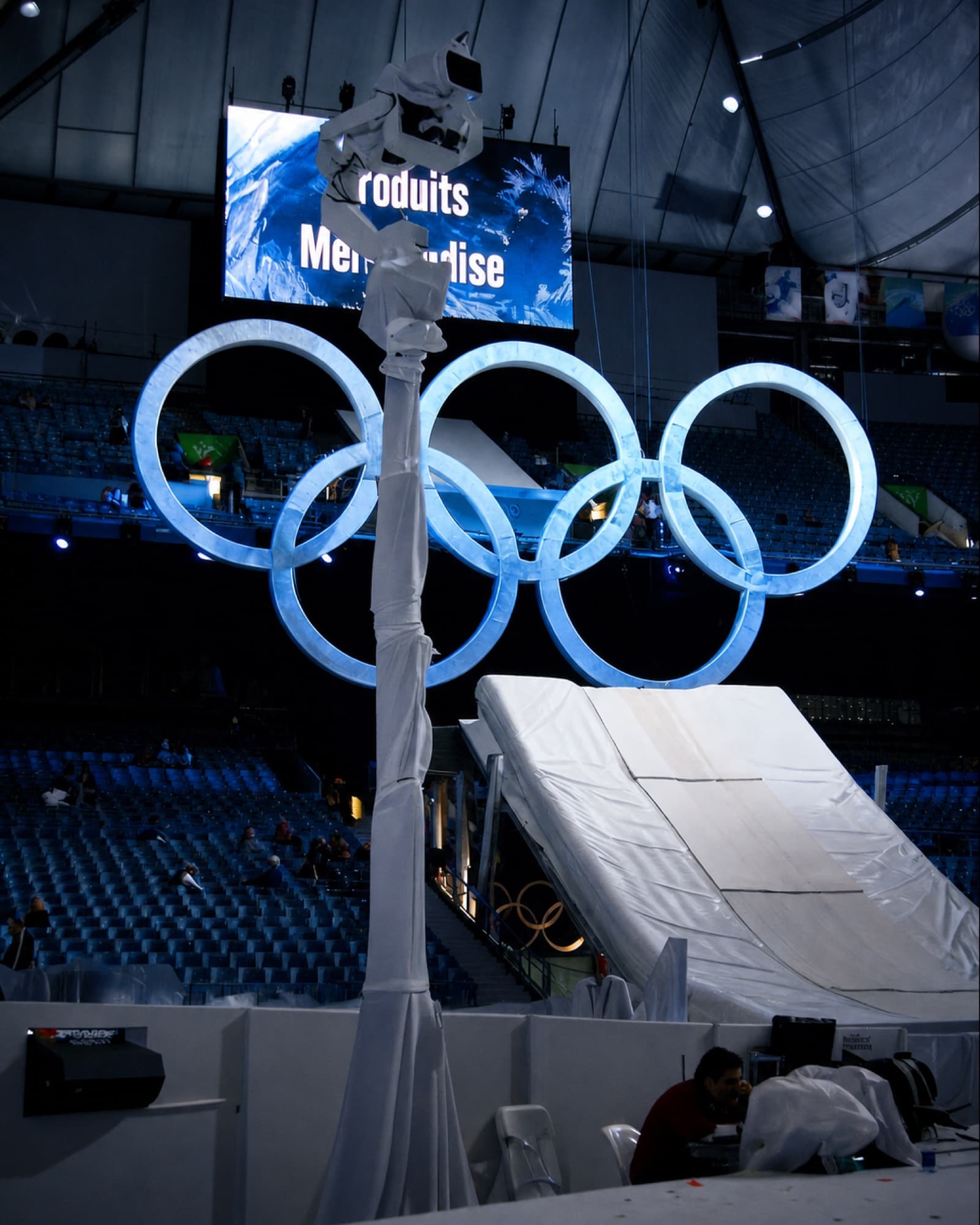 Fluid Pictures Towercam operating beside the illuminated Olympic rings in an arena